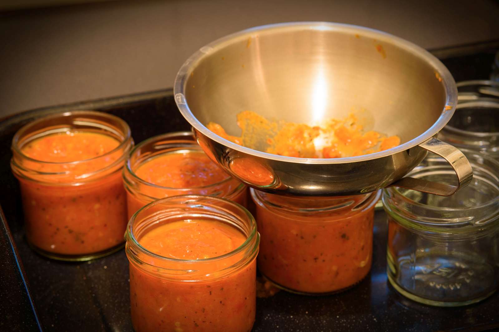 Jarring up. Hot sauce into hot, sterilised jars